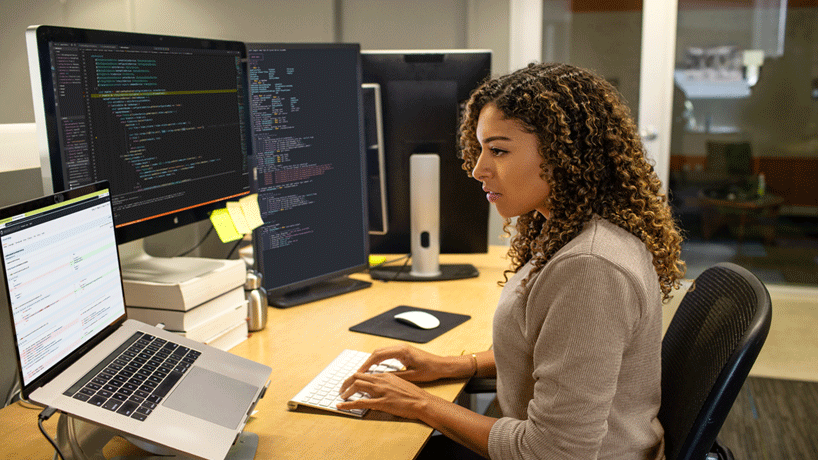 Photo of a woman working in front of monitors